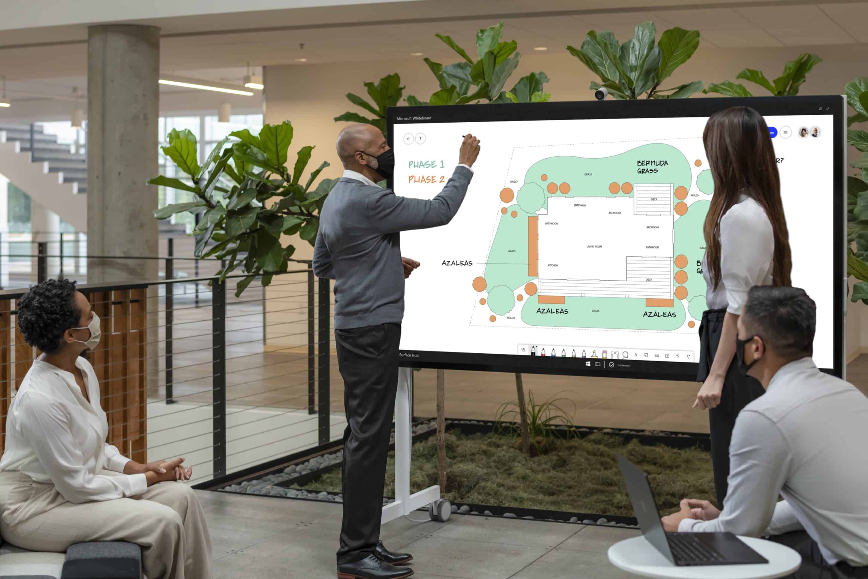 two team members using Microsoft Surface Hub 2S in meeting with team