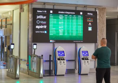 man in front of airport flight information digital signage