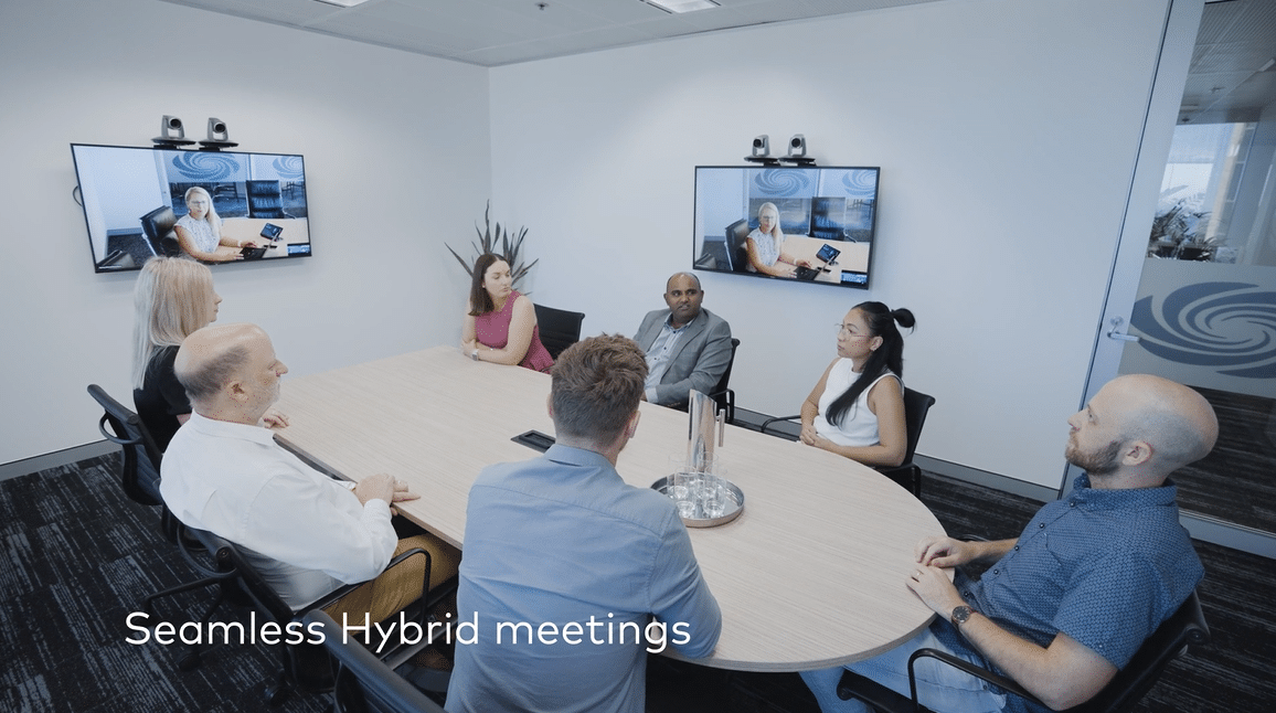 People at conference table with Crestron immersive hybrid work experience