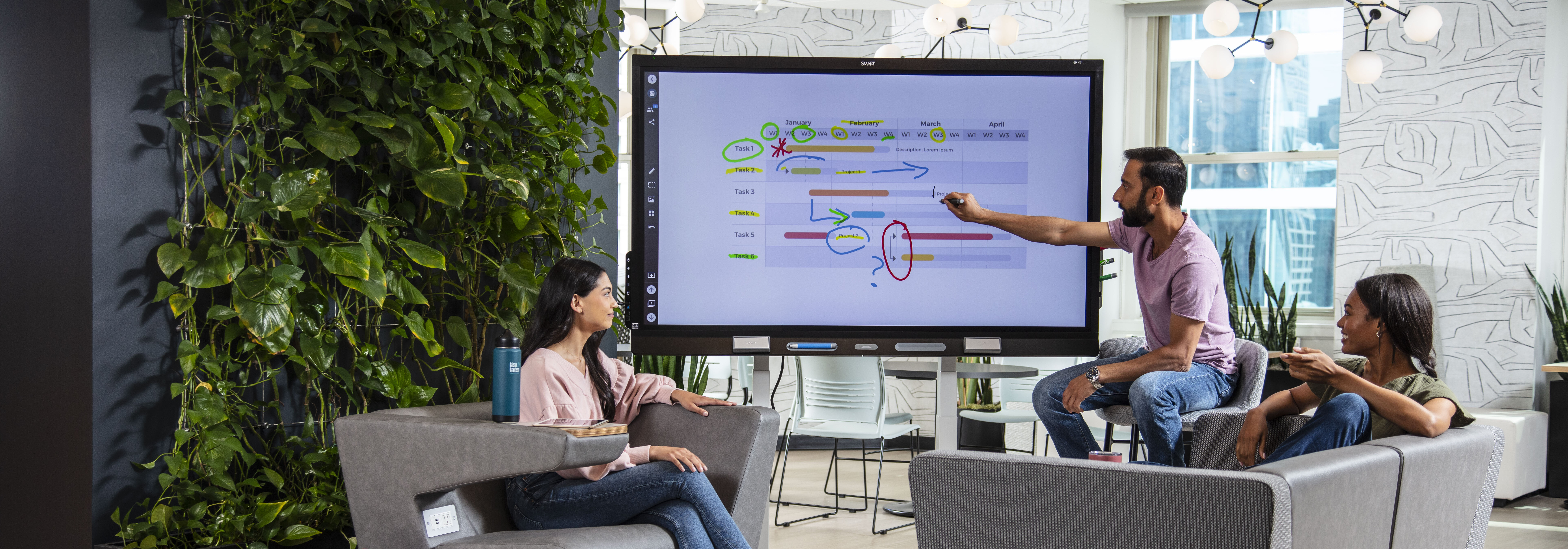 People in a re-designed meeting space with a SMART QX board.