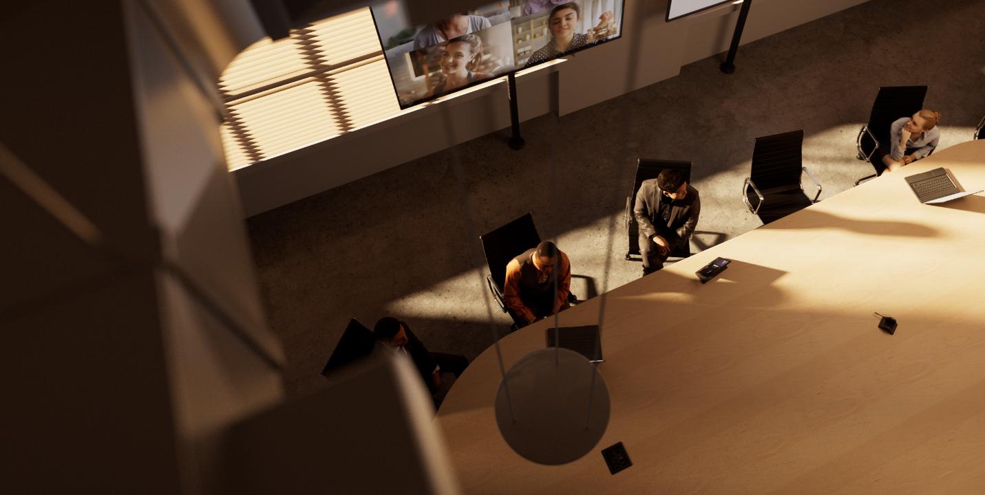 Overhead view: conference table, dim room, video call on wall monitors, laptops & office chairs around the table.