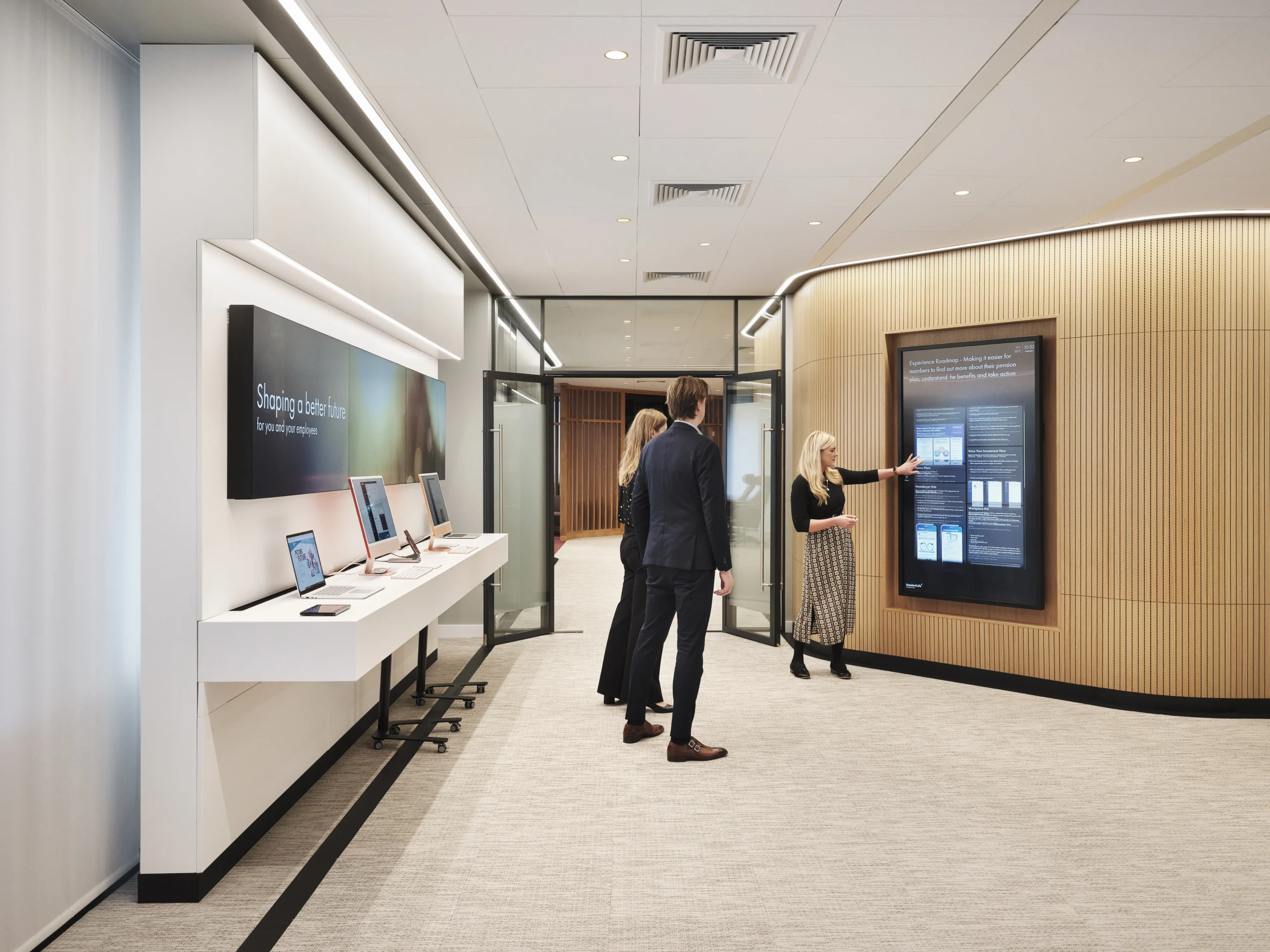 woman using an interactive display with coworkers in a communal space