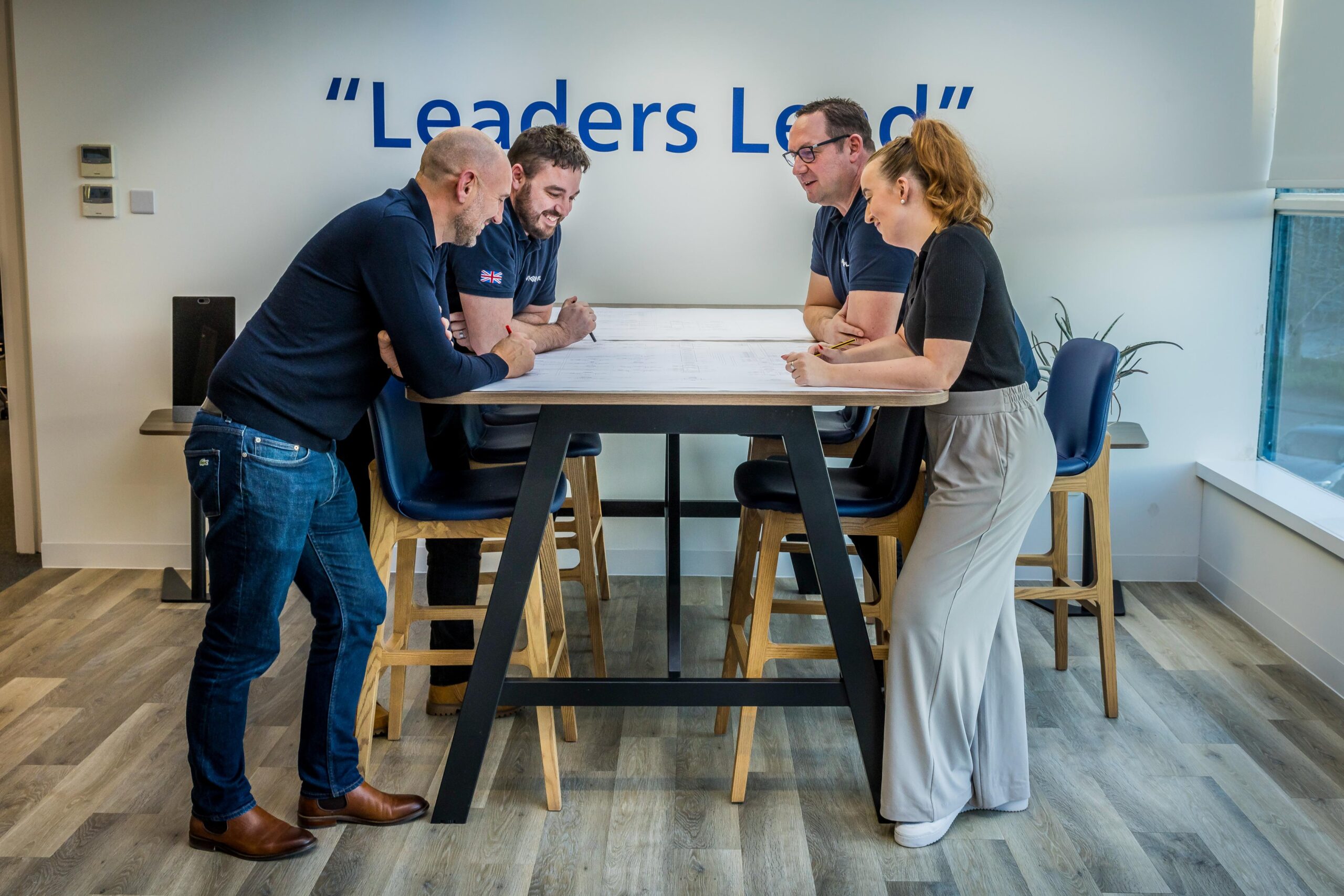 AVI-SPL team members in stand-up meeting around a table