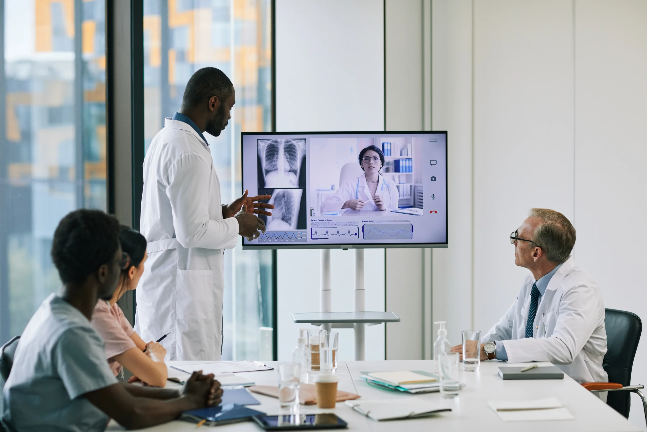 doctors in a hybrid meeting with a remote team and x-ray on the screen