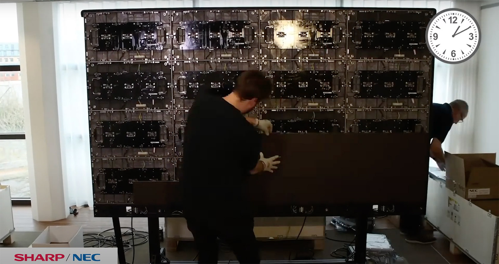 A man assembling Sharp video panels for a large screen