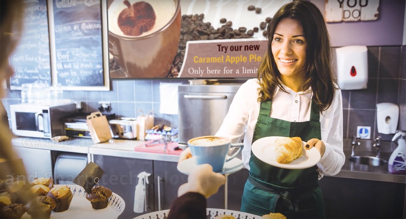 A lady serving Croissant and Coffee to a customer