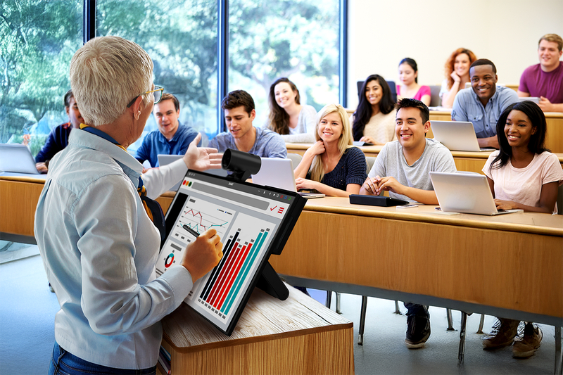 College professor uses a SMART Board Mini at a podium to present to a lecture hall filled with students.