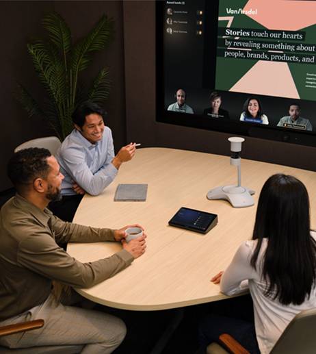 People in a hybrid meeting in a Signature Microsoft Teams Room with a trapezoid table