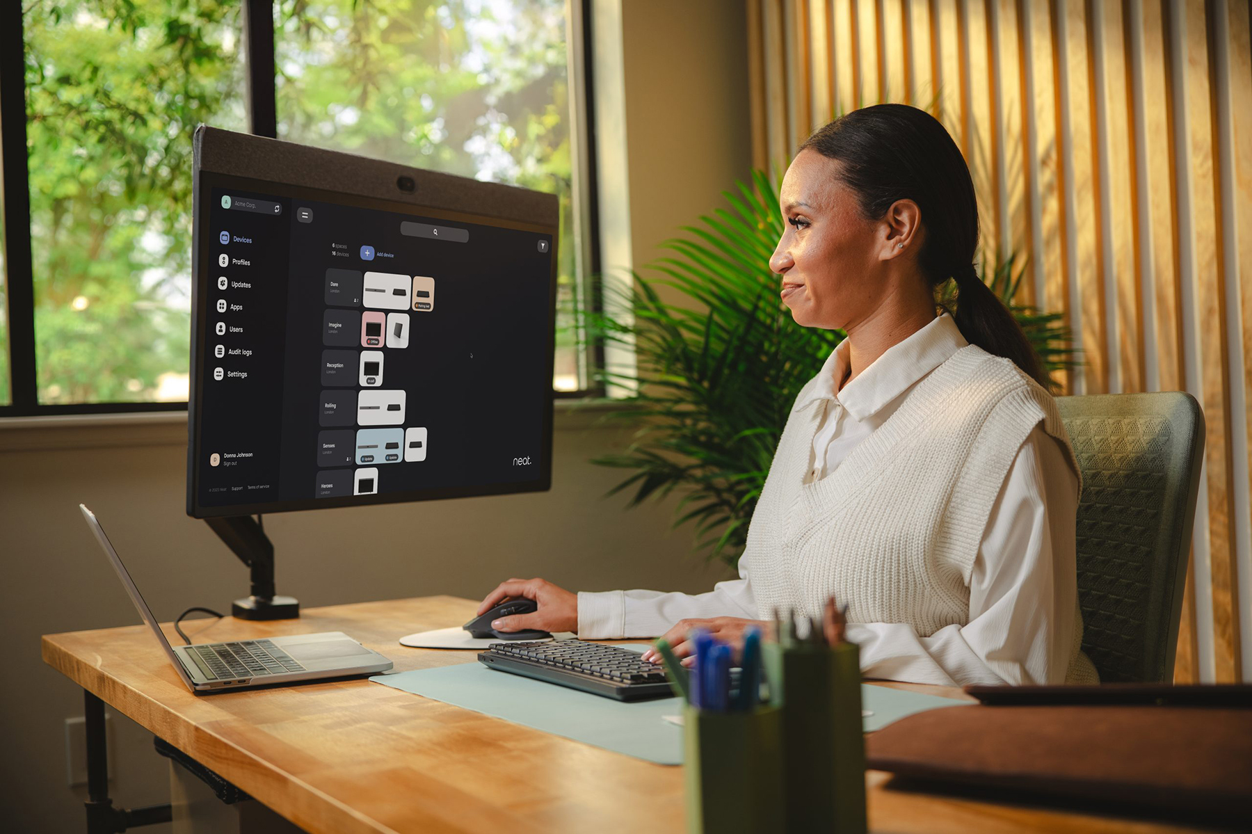 Person sitting at a desk with the Neat Pulse platform on their desktop monitor.