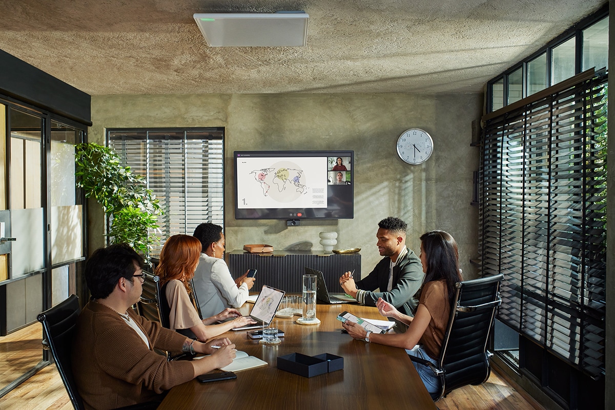 Professionals collaborating in a modern Microsoft Teams Room featuring Shure audio and AI-enabled technology, representing improved meeting ROI and productivity