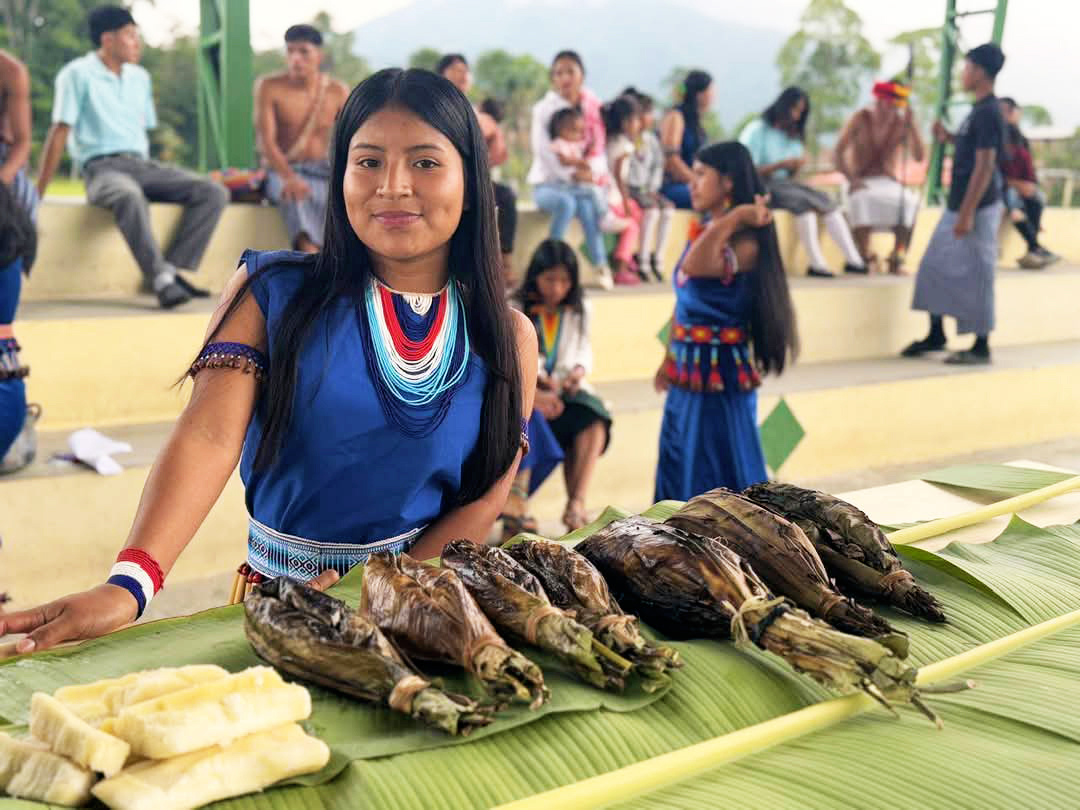 Woman displaying wares on table.