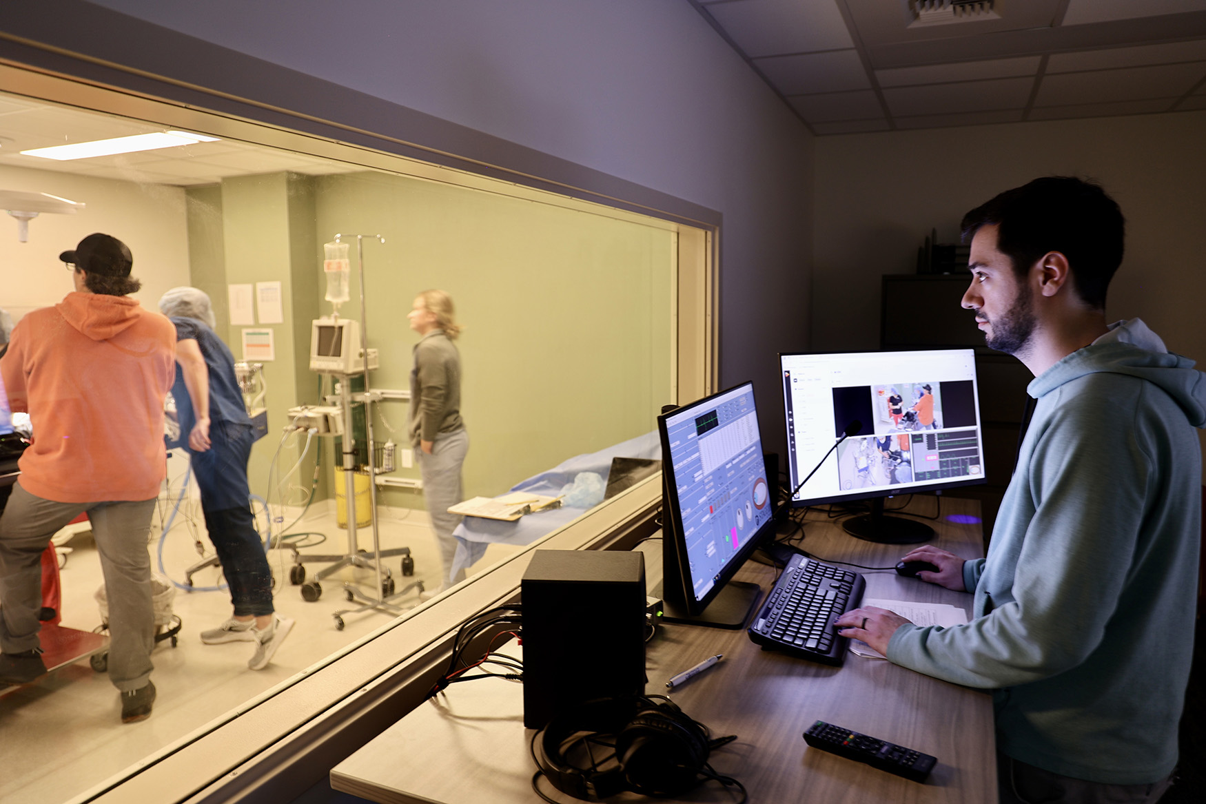 Professor monitors a veterinary medical simulation from the control room.
