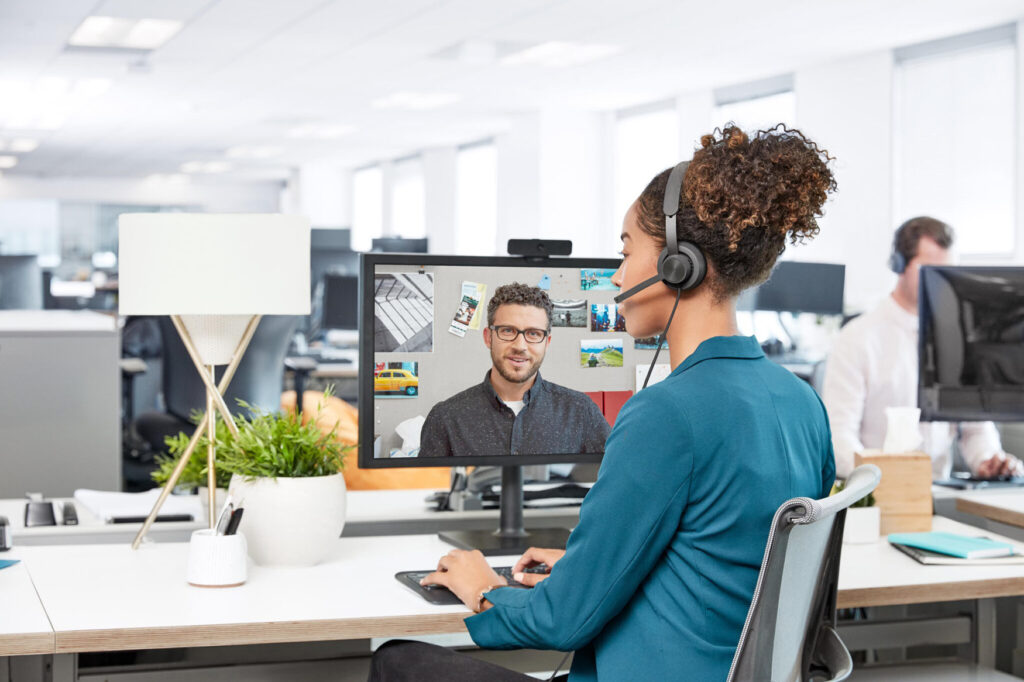 Woman at her desk on a video call with a colleague using Logitech Zone