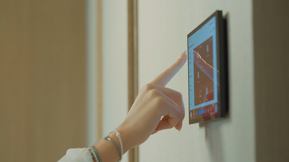 Hand pointing to a wall mounted control panel