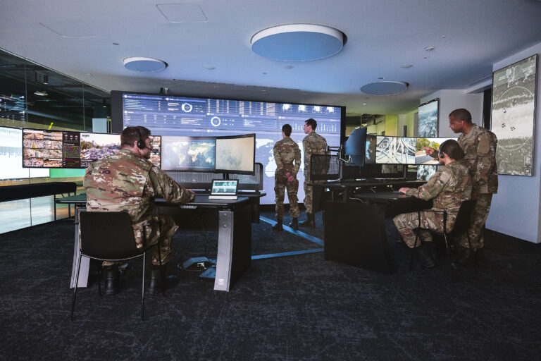 Soldiers-in-military-command-center-with-video-wall-and-desks-768x512